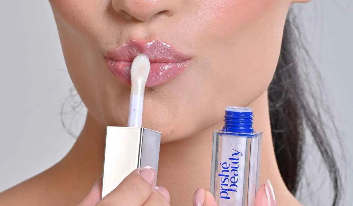 Woman applying hydrating lip gloss for soft, glossy, moisturized lips with natural makeup look.